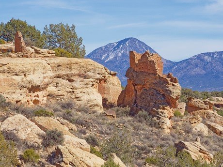 A structure build on a boulder with Sleeping Ute Mountain in the background.