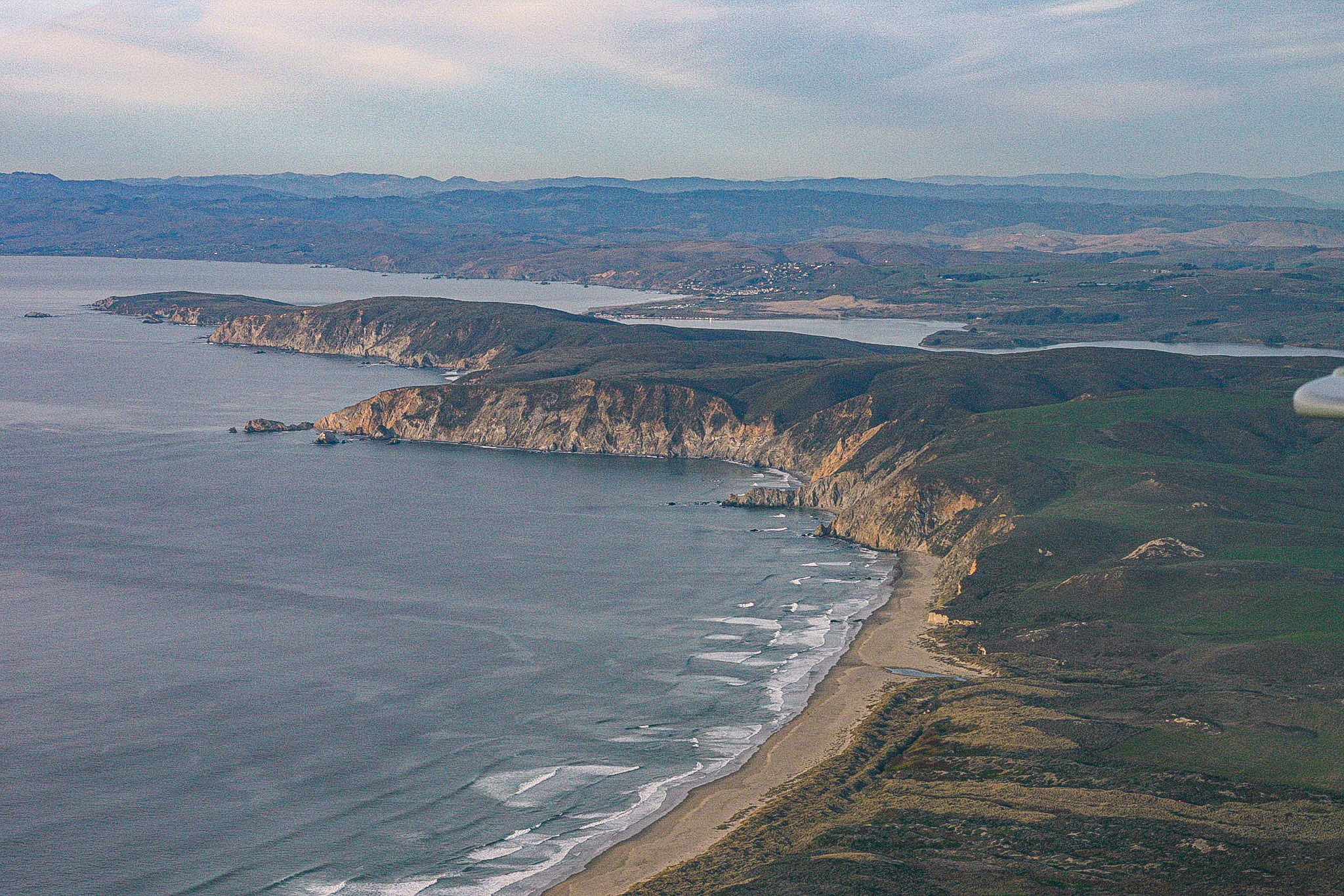 An expansive overhead view of a peninsula jutting out into the ocean.