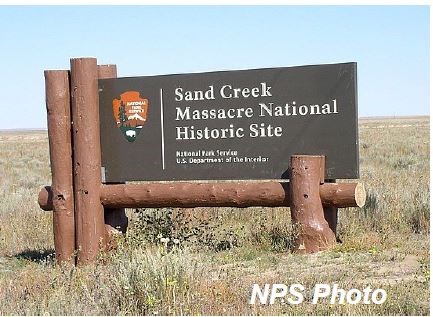 brown sign with an arrowhead that reads Sand Creek Massacre National Historic Site