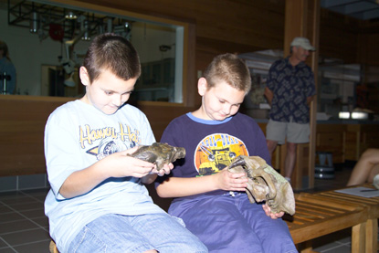 Image of kids looking at and holding fossil skulls.