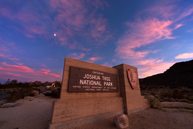 Joshua Tree National Park sign with sunset in background