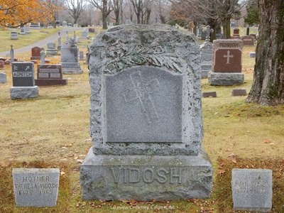 Three grave markers in a cemetery.