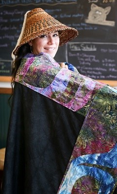 A woman in woven hat and a colorful blanket