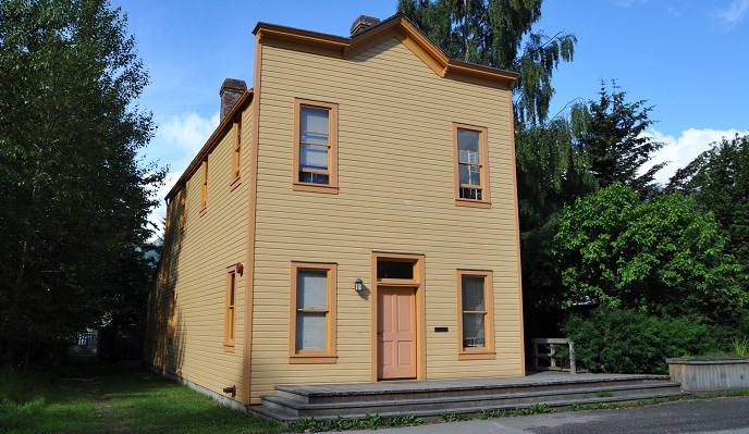 Yellow two story building with visible false front.