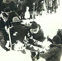 Black and white photo of men digging in the snow.