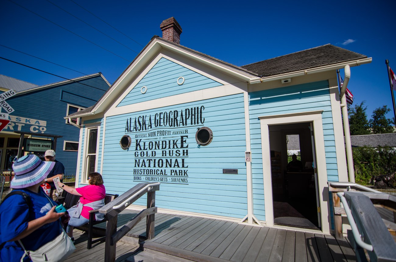 a bright blue building with old timey text reading Alaska Geographic non profit partner of Klondike Gold Rush National Historical Park