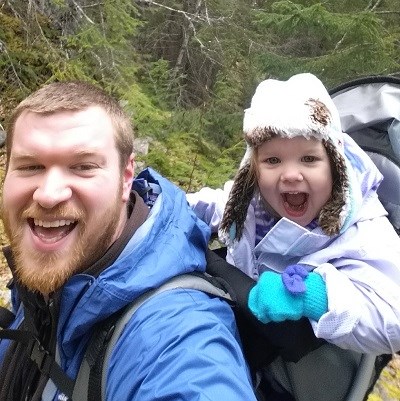 Man on trail with child in in back pack carrier