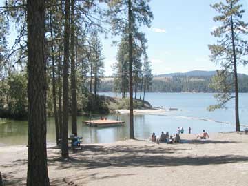 Visitors sitting on the beach at Cloverleaf campground.