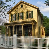 2 story yellow house with a large porch