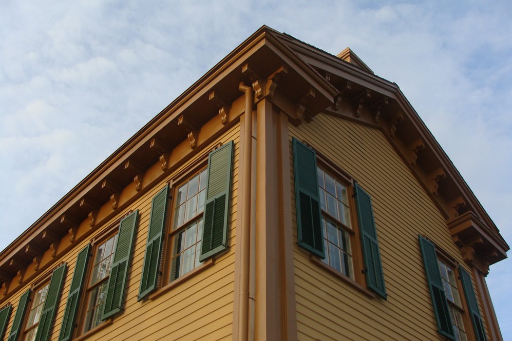 Worm's eye photo of the Lincoln Home (tan with green shutters)