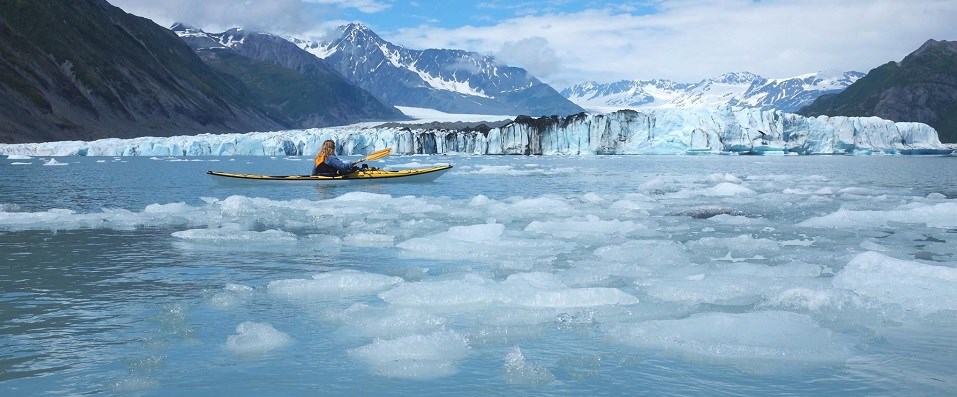 Woman kayaking through icy Alaskan waters