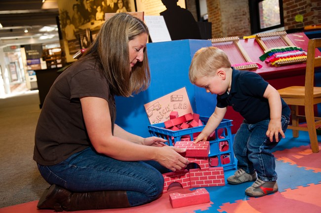 A mother and son play with foam blocks at the Visitor Center