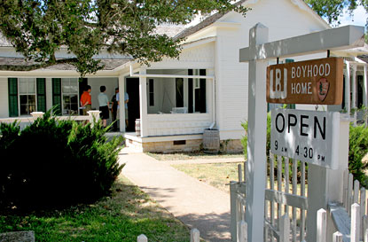 Visitors join a tour on the front porch of President Johnson's childhood home.