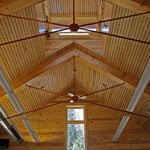 The warm tones of interior wood paneling contrast with sunlit greenery glimpsed through windows. NPS Photo.