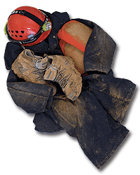 Dirty caving gear - helmet, kneepads, boots and coveralls