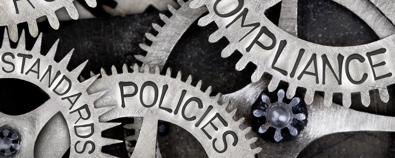 An image with a bunch of gears. Some read "policies" and "compliance."