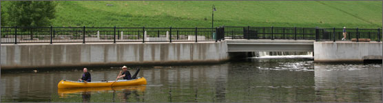 Two people canoeing down the Mississippi River near the Minneapolis riverfront.