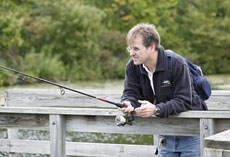 A man fishes from a pier.