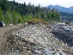 Heavy equipment moves rocks on levee