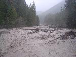 Brown and churning waters of a wide creek