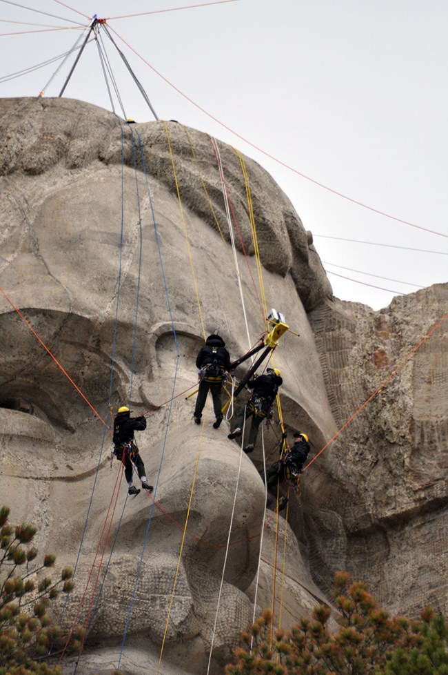 Mount Rushmore's rope access team scans Theodore Roosevelt.