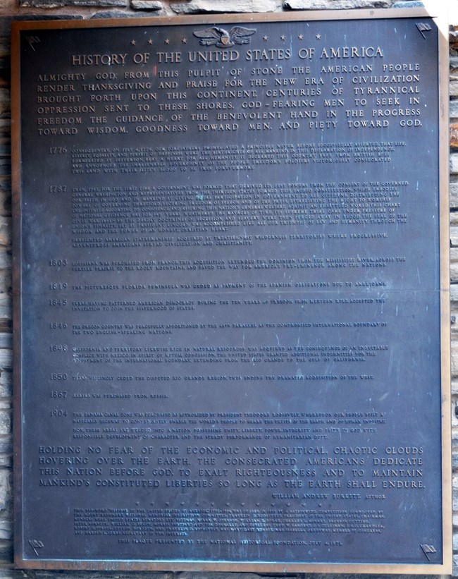 A large bronze plaque inscribed with the winning essay titled "History of the United States of America" written by William Burke.  The plaque is located at the Borglum View Terrace, the site of the first studio at Mount Rushmore.