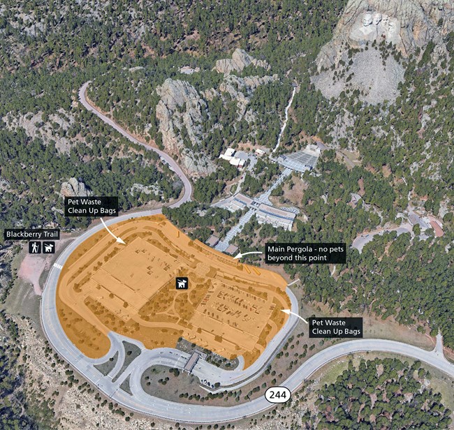 Aerial photo of the grounds at Mount Rushmore with the pet areas near the parking garages highlighted in the middle of the lower half of the image and the location of the Blackberry Trail marked on the far left side of the image.