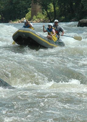 Three individuals ride through a white water rapid on the New River in West Virginia. Three individuals ride through a white water rapid on the New River in West Virginia.