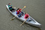 A volunteer helps three girls paddle a canoe down the Niobrara NSR.