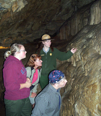 A Ranger shows visitors flowstone formations on a cave tour. A Ranger shows visitors flowstone formations on a cave tour.