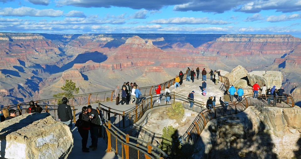 Groups of visitors at an overlook over the Grand Canyon