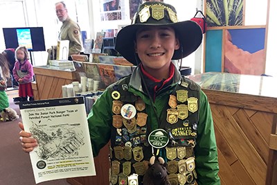 Junior Ranger Tigran shows off his badges and certificate