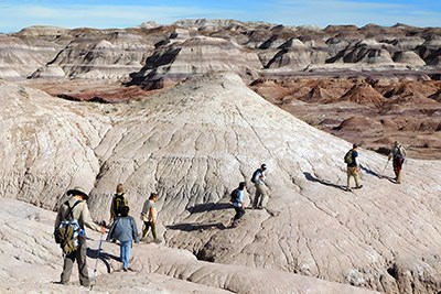 Backcountry hikers amidst color badlands.