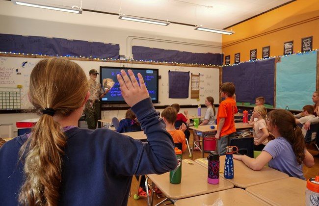 a classroom of students take a junior ranger pledge