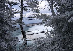 This far-away photo of Miners Beach was taken from the trail to Miners Castle, through snow-covered trees.