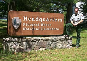 Park Ranger with Headquarters entrance sign