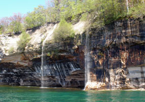 Springtime waterfalls tumble over the Pictured Rocks cliffs into Lake Superior.