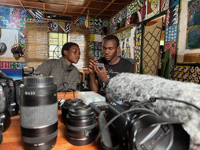 Two Rwandan Film students look over media equipment.