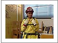 A small photo of a young female fire fighter in a classroom.