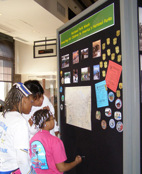 Two girls and their mother find a national park on a map for National Park Wee activities.
