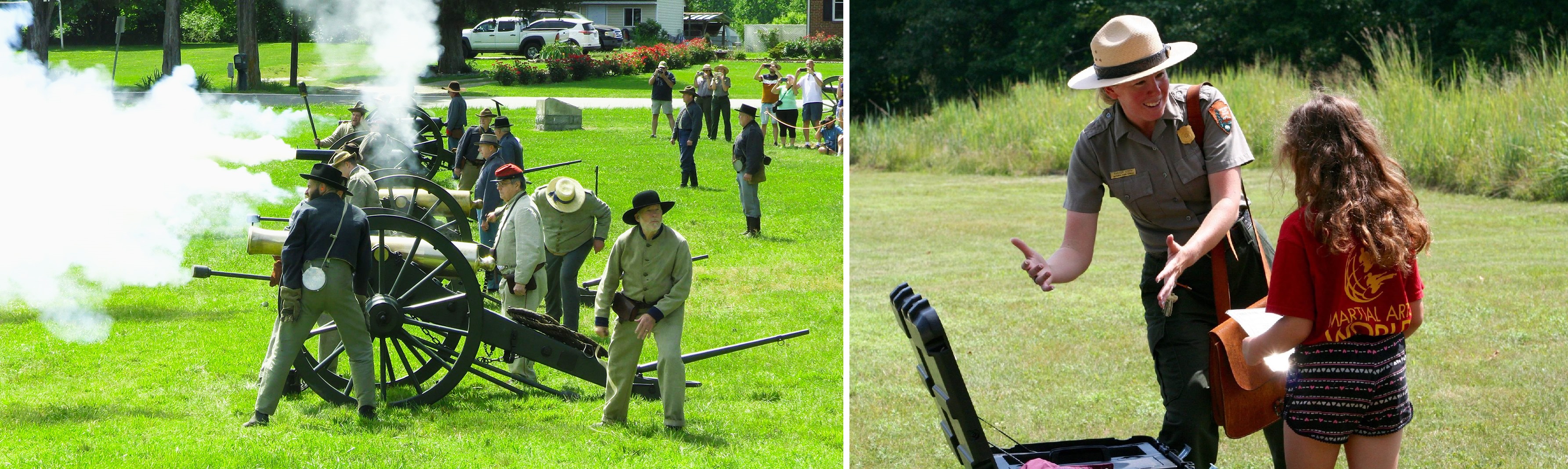 Four Civil War cannons, side by side, are fired by costumed reenactors, and a uniformed park ranger speaks to a child.