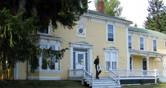 Man with shopping back exiting yellow building