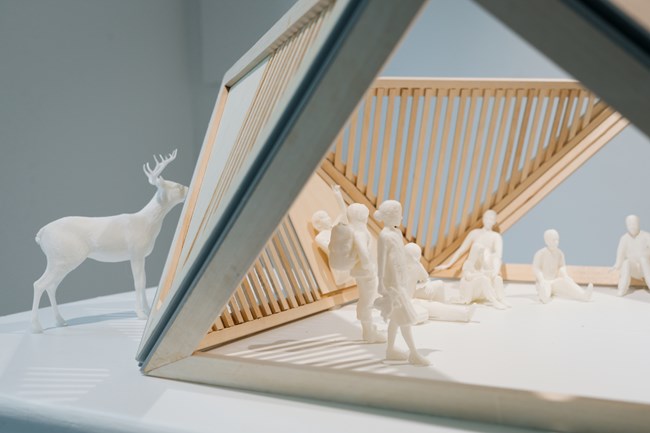 small figurines of people and deer with wooden structure