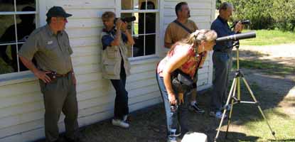 Visitors use a spotting scope to view an osprey nest at the English Camp visitor center.