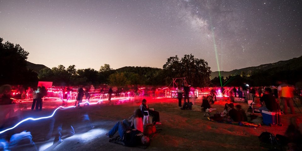 Visitors gaze at the night sky while laser pointers display constellations