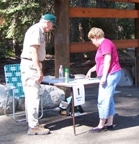 Volunteer assists a visitor near the Sherman Tree