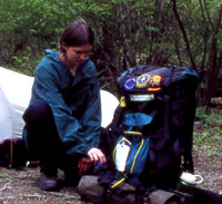 A backcountry camper sets up her campsite.
