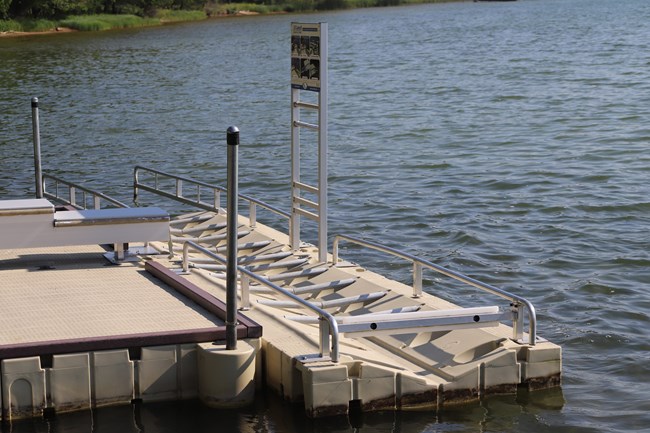 A floating dock with attached plastic and metal boat launch.