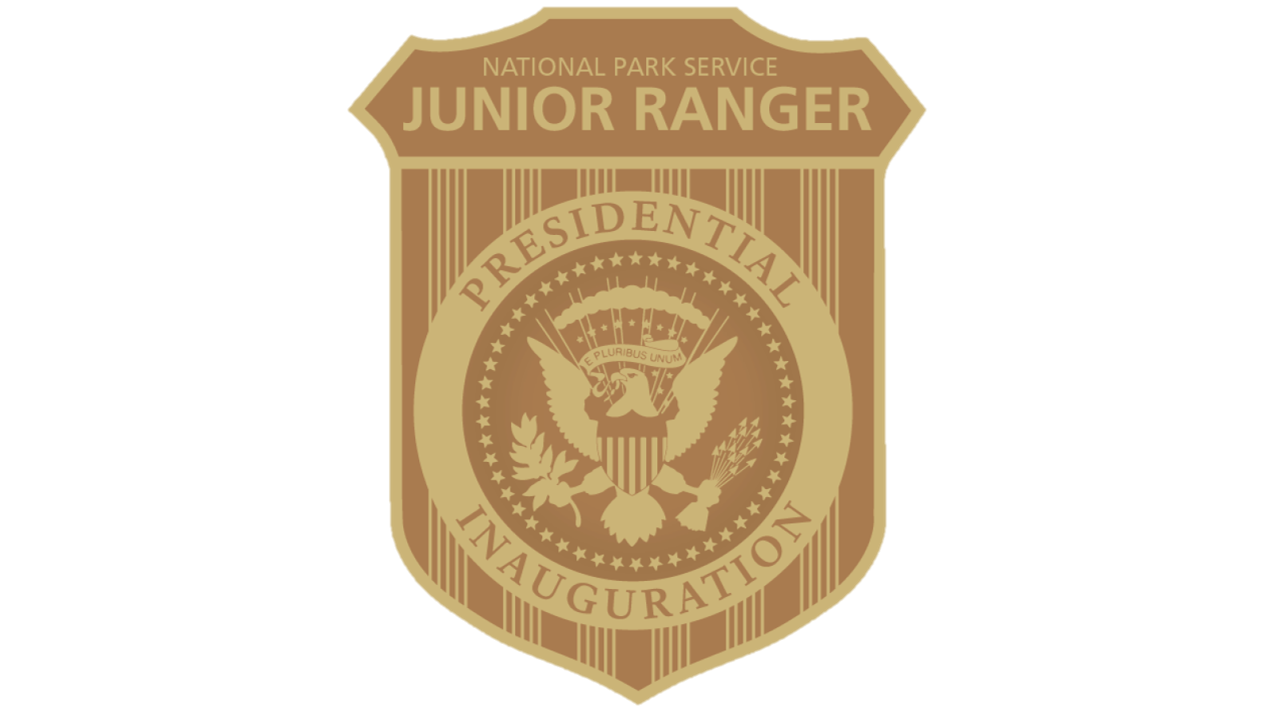A yellow and gold badge showing the presidential seal and text that reads "National Park Service Junior Ranger Presidential Inauguration"
