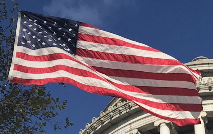 An American flag flies under a sunny sky